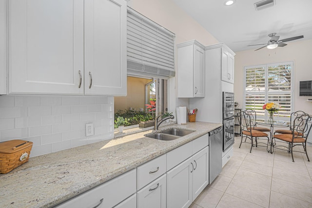 kitchen with visible vents, appliances with stainless steel finishes, white cabinetry, a sink, and light tile patterned flooring