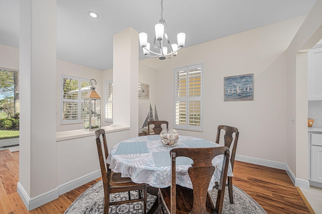 dining room with baseboards, an inviting chandelier, and light wood-style floors