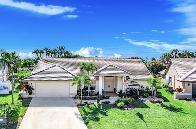 view of front facade featuring a garage, driveway, and a tiled roof