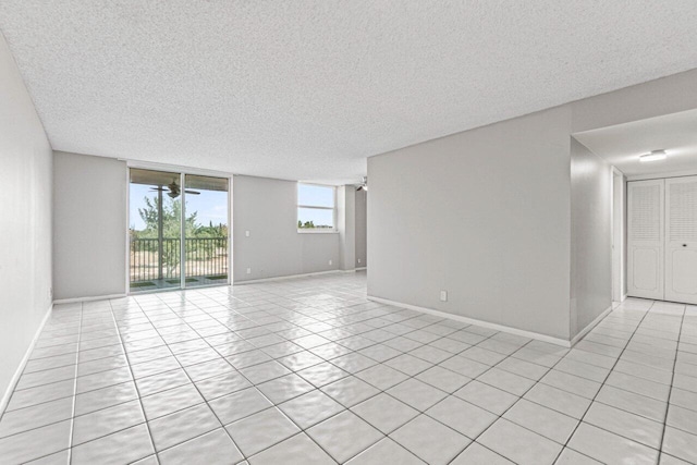 5700 NW 2nd Ave Unit 401, Boca Raton, FL 33487 - empty room with baseboards, a textured ceiling, and light tile patterned flooring
