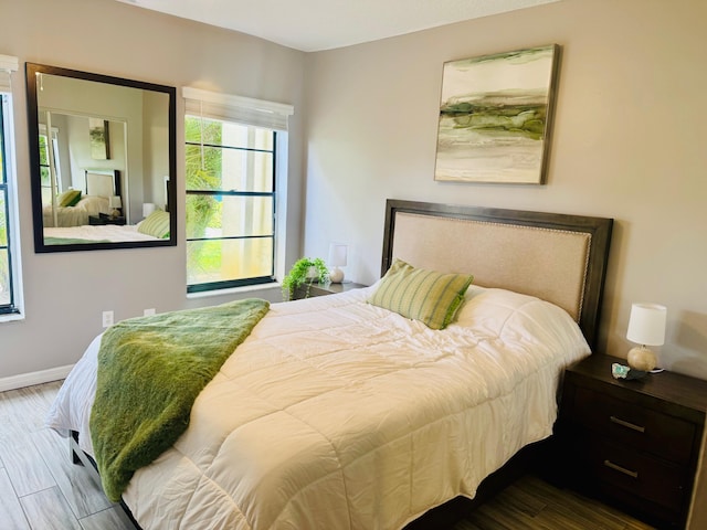 bedroom featuring baseboards and wood finished floors