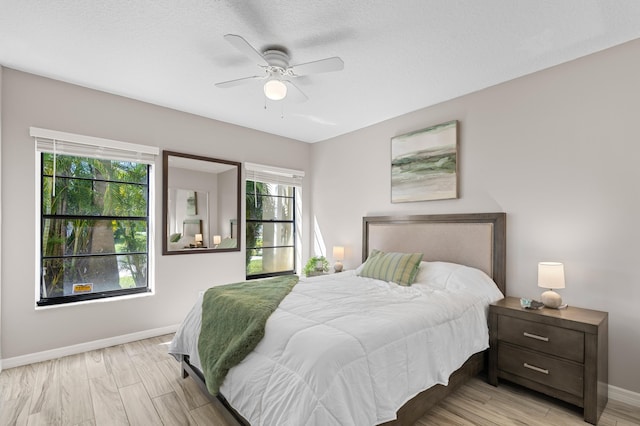 bedroom featuring ceiling fan, light wood finished floors, and baseboards