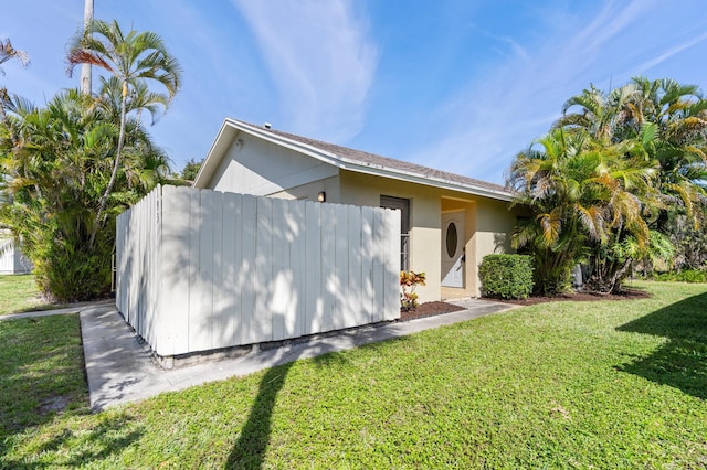 exterior space with a lawn and stucco siding