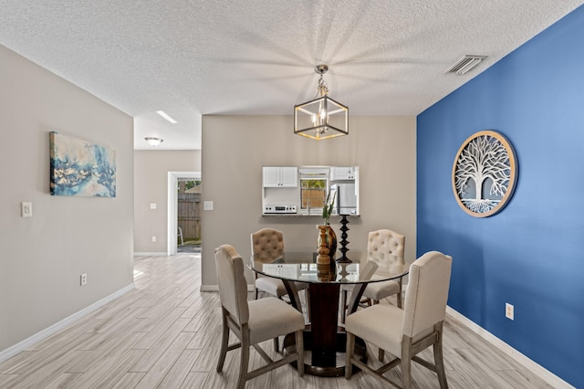 dining space featuring visible vents, light wood-style flooring, and baseboards