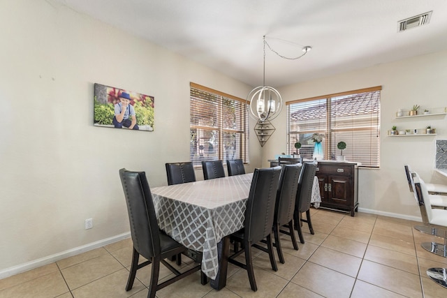 dining space with an inviting chandelier, light tile patterned floors, baseboards, and visible vents