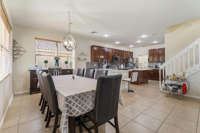 dining room featuring light tile patterned floors, visible vents, plenty of natural light, and stairs