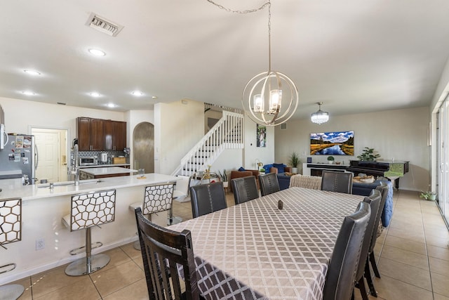 dining room with light tile patterned floors, visible vents, an inviting chandelier, recessed lighting, and stairs