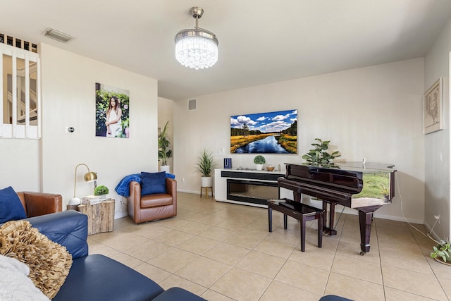 living room featuring a notable chandelier, light tile patterned flooring, baseboards, and visible vents