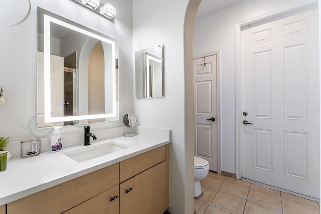 full bath featuring vanity, tile patterned floors, toilet, and walk in shower