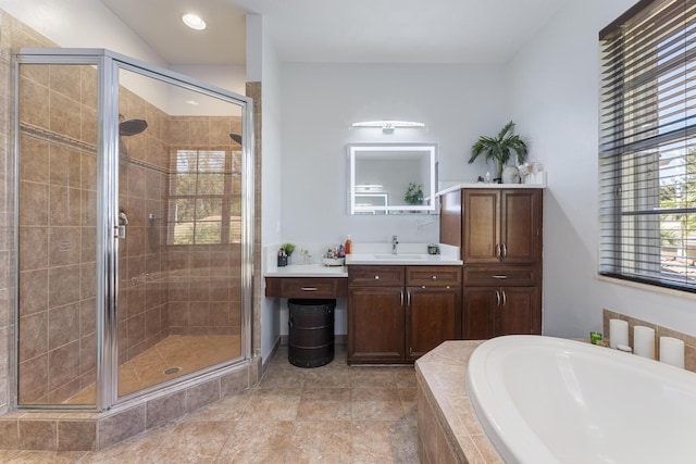 bathroom with a garden tub, a stall shower, and vanity