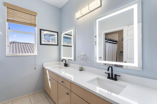 full bath with tile patterned floors, a shower with curtain, double vanity, and a sink