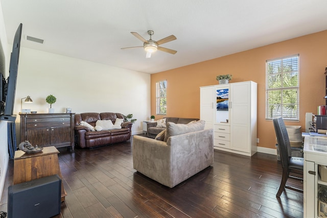 living room with dark wood-type flooring, baseboards, visible vents, and ceiling fan