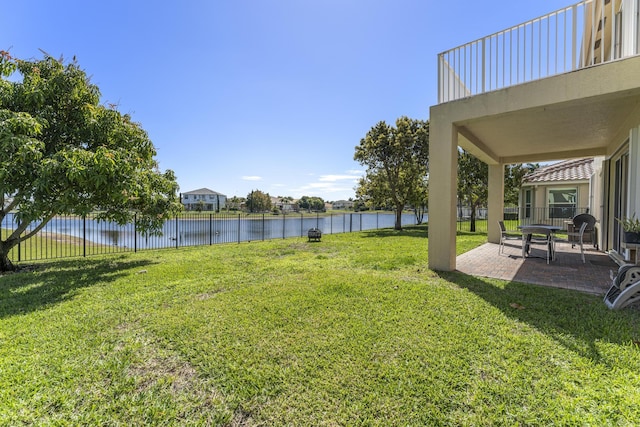 view of yard featuring fence, a patio, and a water view