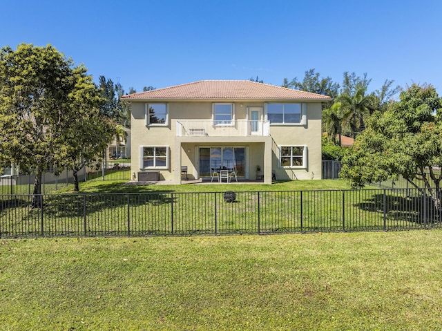 rear view of property featuring a balcony, a fenced backyard, and stucco siding