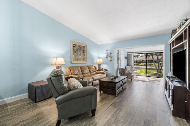 living room with lofted ceiling, baseboards, and wood finished floors