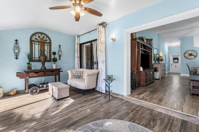 sitting room with vaulted ceiling, wood finished floors, visible vents, and a ceiling fan