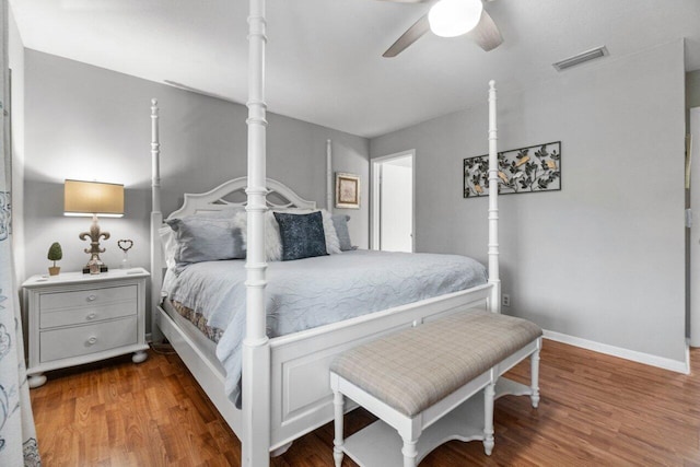 bedroom featuring a ceiling fan, wood finished floors, visible vents, and baseboards