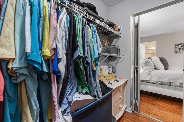 walk in closet with wood finished floors