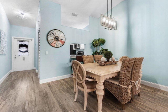 dining area with visible vents, baseboards, and wood finished floors