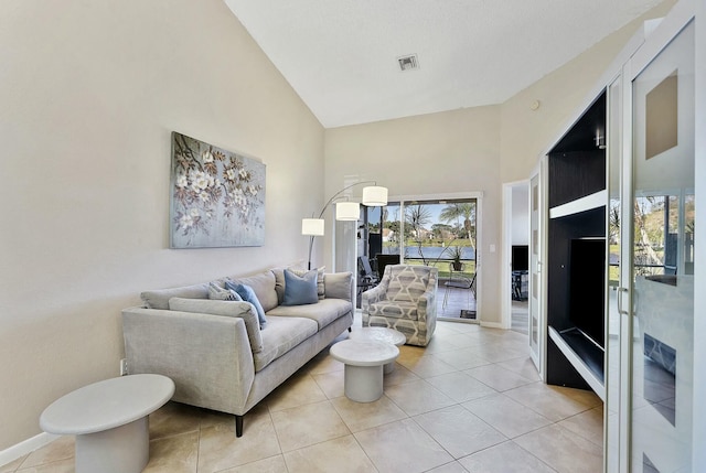 living room featuring high vaulted ceiling, baseboards, and light tile patterned floors