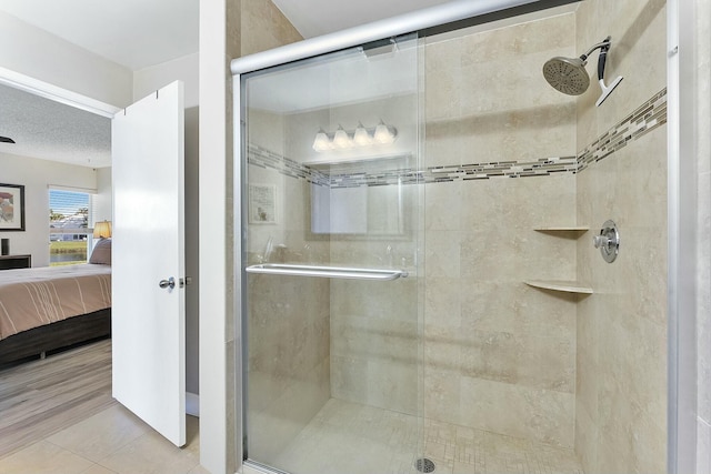 full bath featuring a stall shower, ensuite bath, a textured ceiling, and tile patterned floors