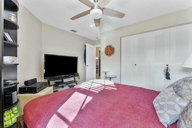 bedroom featuring a textured ceiling, a closet, visible vents, and a ceiling fan