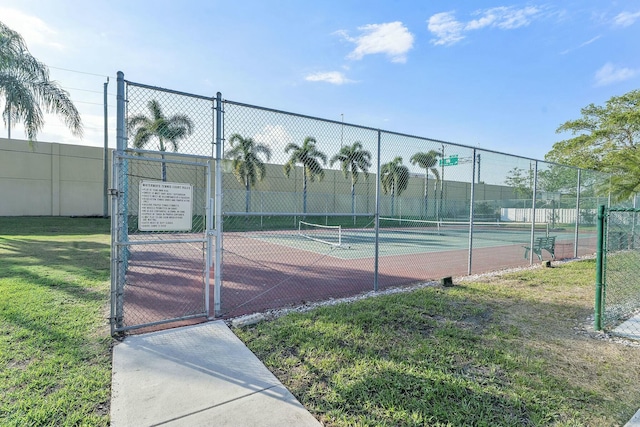 view of sport court with a gate, fence, and a yard