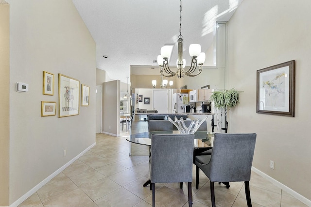 dining area featuring a chandelier, a high ceiling, light tile patterned flooring, and baseboards