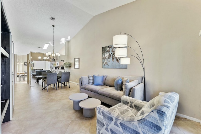 living area featuring high vaulted ceiling, light tile patterned flooring, a notable chandelier, visible vents, and baseboards