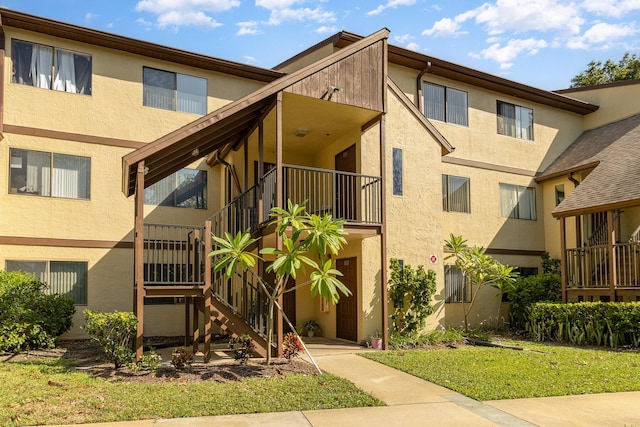 view of front facade featuring stairs and stucco siding