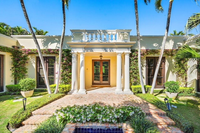 property entrance featuring stucco siding and french doors