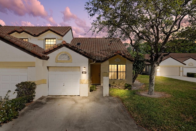 view of front of house featuring driveway, an attached garage, a tiled roof, and a front yard