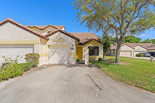 view of front facade featuring a front yard, a tiled roof, a garage, aphalt driveway, and stucco siding