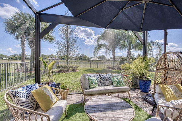 view of patio featuring an outdoor hangout area, glass enclosure, a rural view, and a fenced backyard