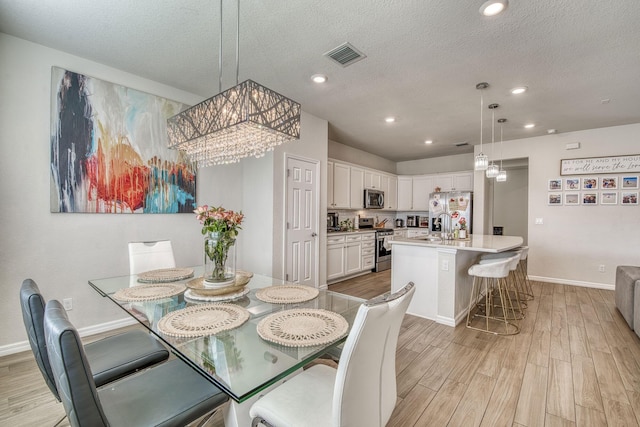 800 SE Villandry Way, Port Saint Lucie, FL 34984 - dining space featuring light wood finished floors, baseboards, a chandelier, a textured ceiling, and recessed lighting