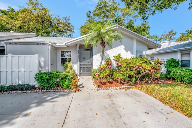 view of front of home featuring fence and stucco siding