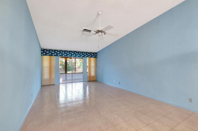 empty room featuring lofted ceiling, ceiling fan, visible vents, and baseboards