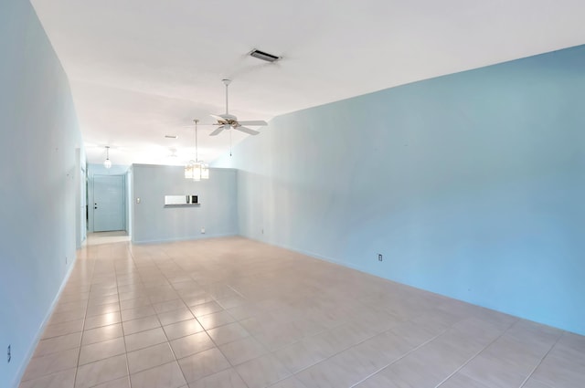 spare room with lofted ceiling, light tile patterned floors, visible vents, and a ceiling fan