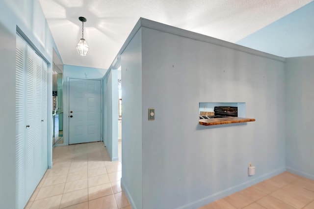 corridor with baseboards and light tile patterned flooring