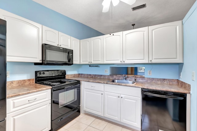 kitchen featuring visible vents, a sink, black appliances, and white cabinetry