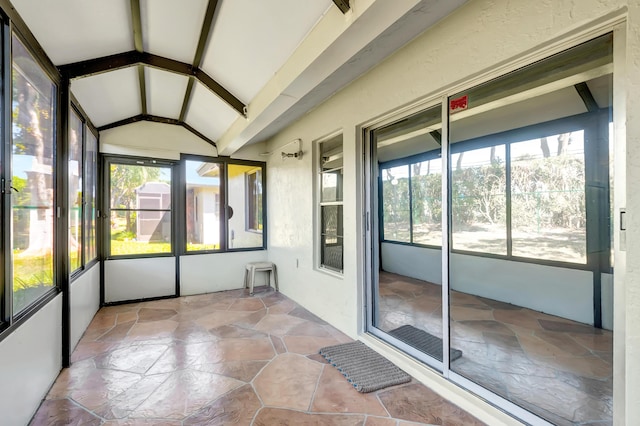 unfurnished sunroom with lofted ceiling with beams