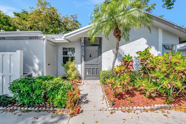 entrance to property featuring stucco siding