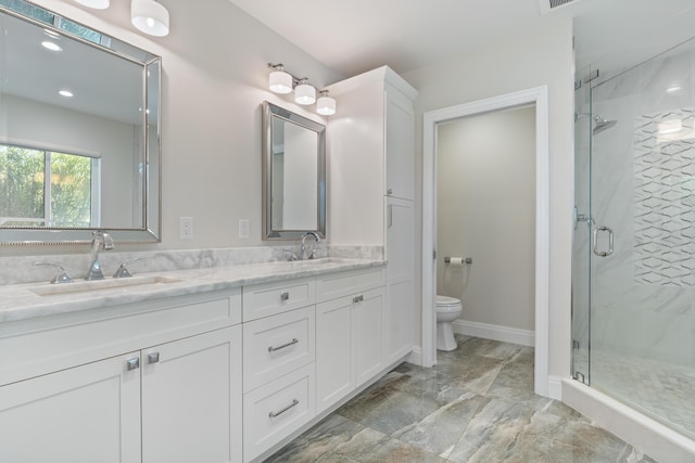 bathroom featuring a sink, a shower stall, and toilet