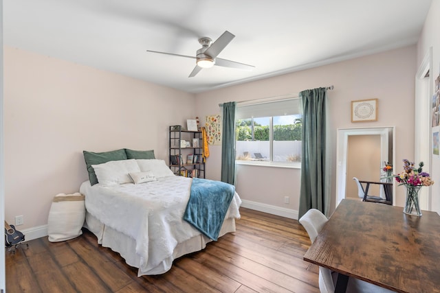 bedroom with ceiling fan, dark wood-type flooring, and baseboards