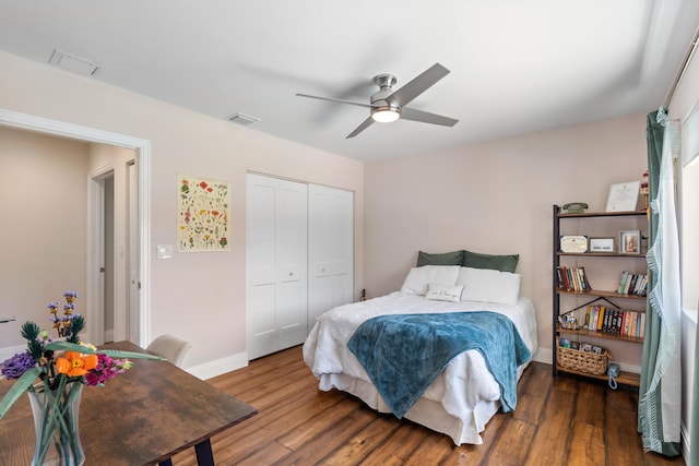 bedroom featuring baseboards, a closet, visible vents, and wood finished floors