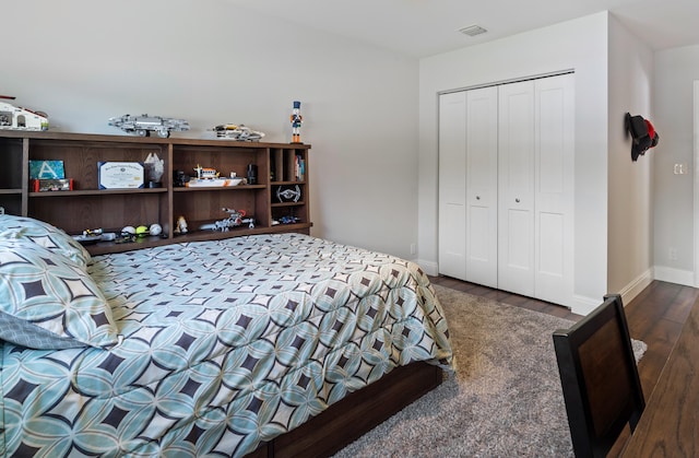 bedroom with a closet, visible vents, baseboards, and dark wood-style flooring