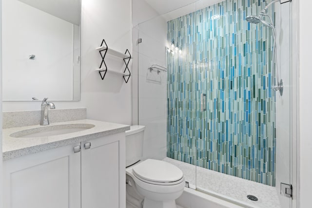 bathroom with a shower stall, toilet, and vanity