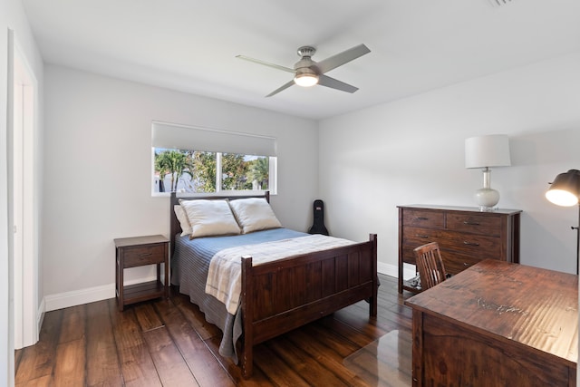 bedroom with dark wood finished floors, a ceiling fan, and baseboards