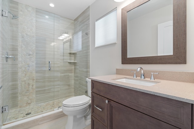 bathroom featuring a stall shower, vanity, and toilet