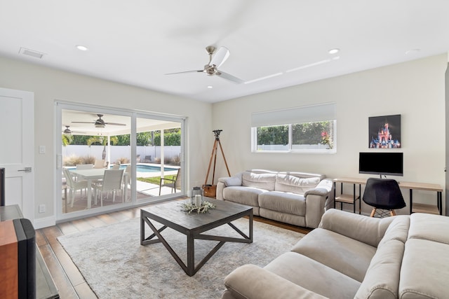 living room with recessed lighting, visible vents, ceiling fan, light wood-type flooring, and baseboards